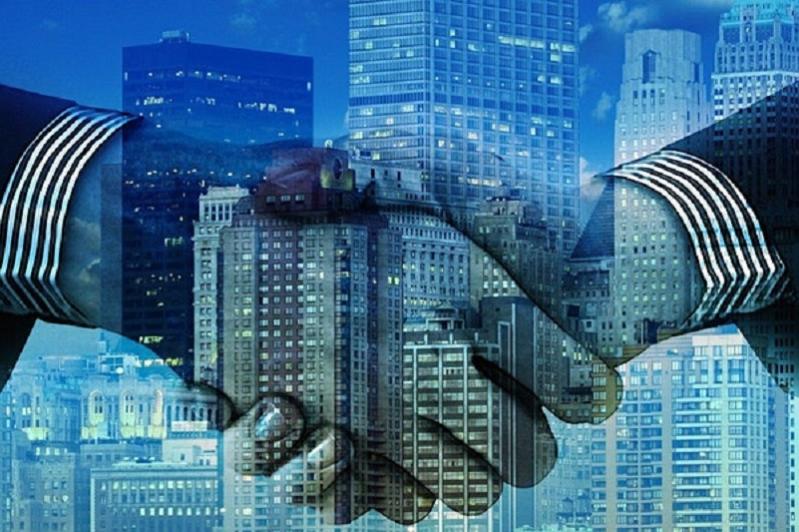handshake overlaid on cityscape image
