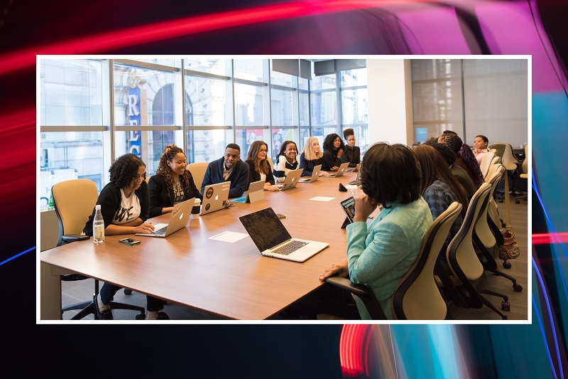 BAME staff chatting in meeting room wearing face coverings