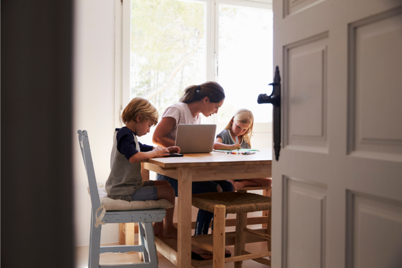 mum working while helping her kids with homework