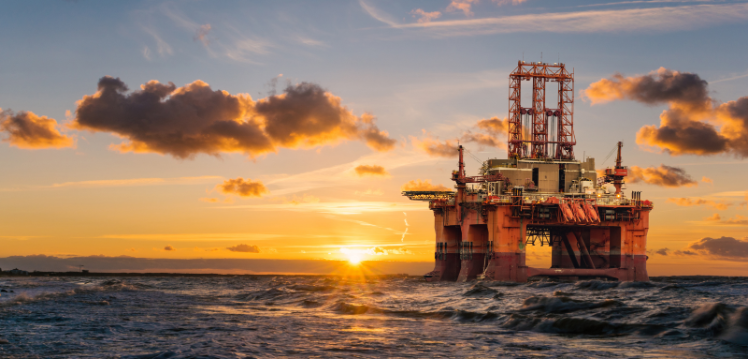 Image of an oil rig in the sea at sunrise