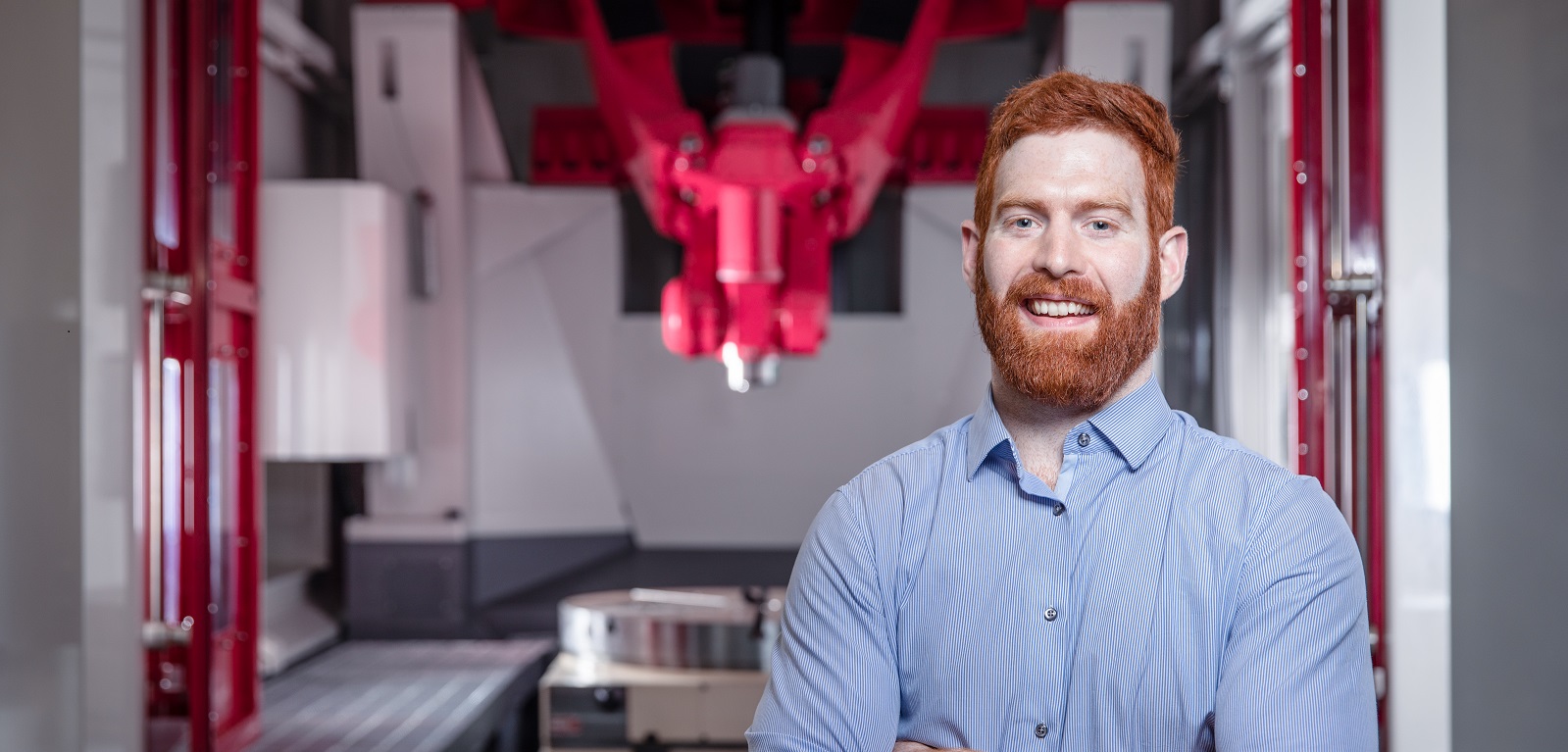 Dan Reid, Technician at Queen's University Belfast, standing in front of technical equipment