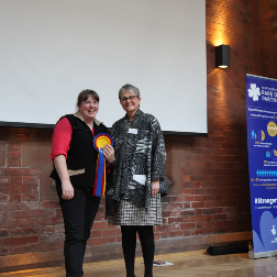 Professor Amy Jayne McKnight accepting Rare Disease Day award from Baroness Ritchie smiling.