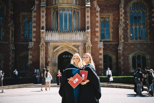 two female graduates outside Queen's University in graduation gowns