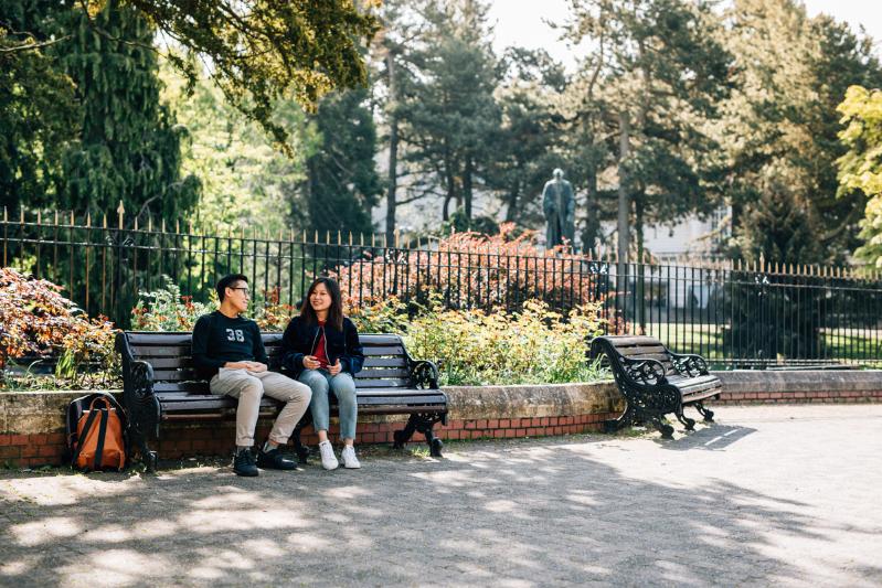 Two students sitting on a bench in Botanic Gardens.