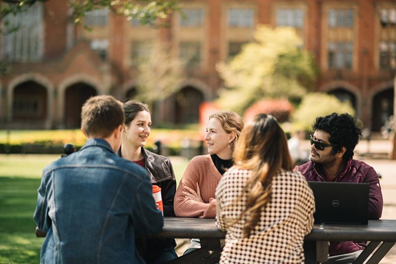 Group of students at a picnic table in the quad