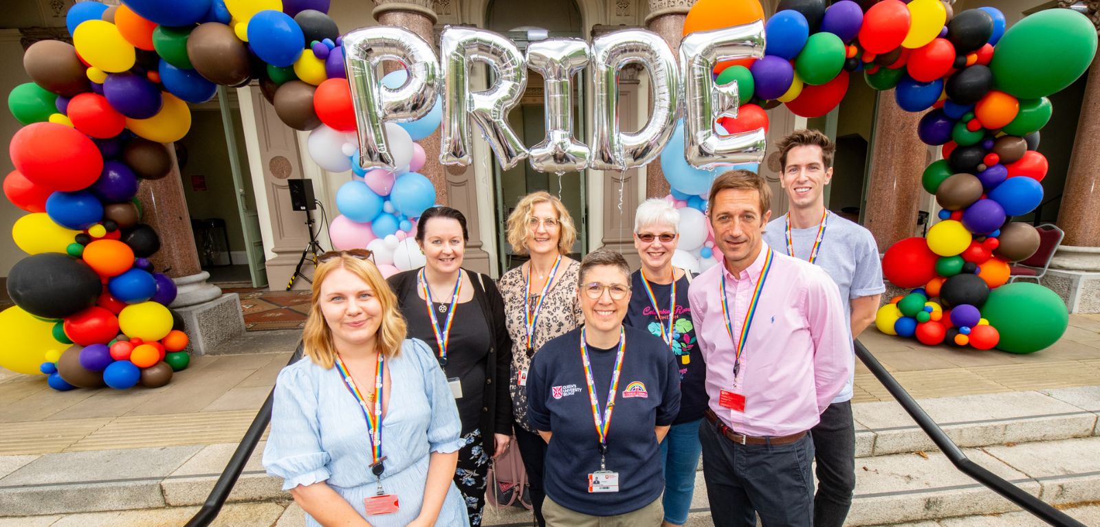 Staff pictured in front of Pride balloons