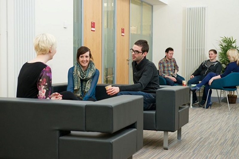 people sitting and chatting in an office lounge area