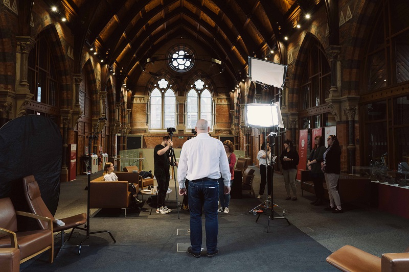 promo image for Staff Charter Launch 2022, showing film/photography crew and equipment, University staff and others in The Graduate School