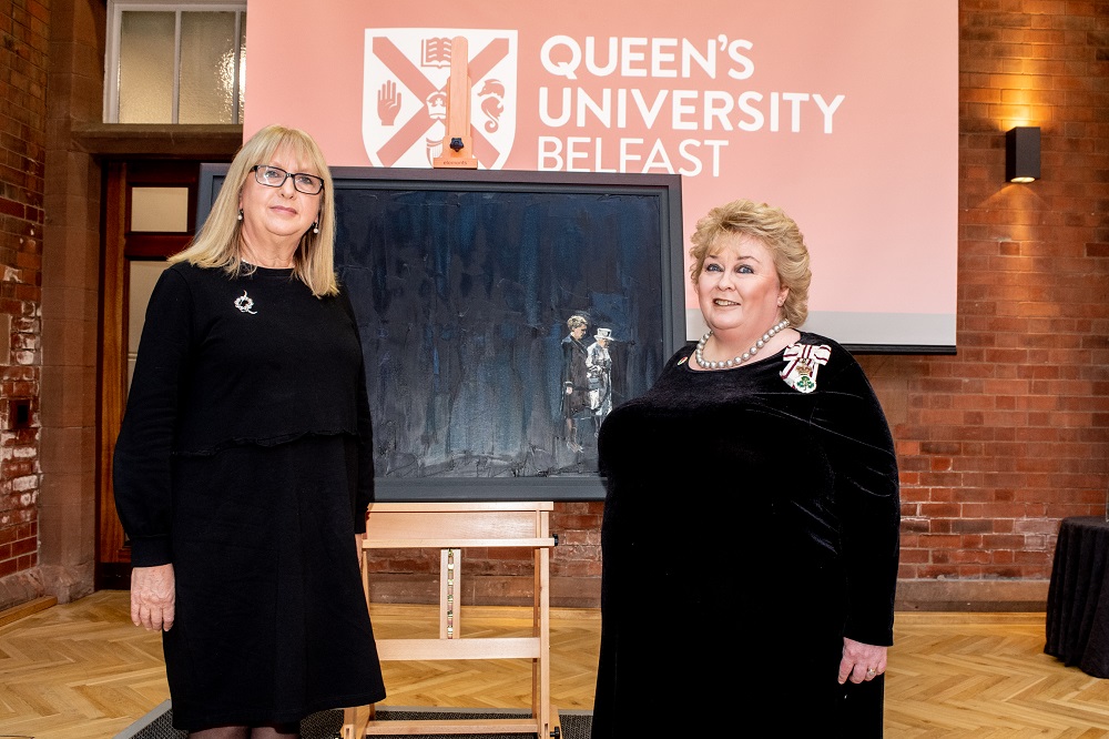 Professor Mary McAleese with Lord Lieutenant Dame Fionnuala Jay-O'Boyle either side of the portrait of Queen Elizabeth II and McAleese by artist Michelle Rogers