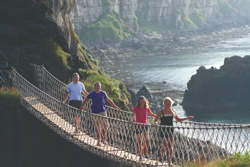Image shows a group of tourists on Carrick-a-rede Rope Bridge.