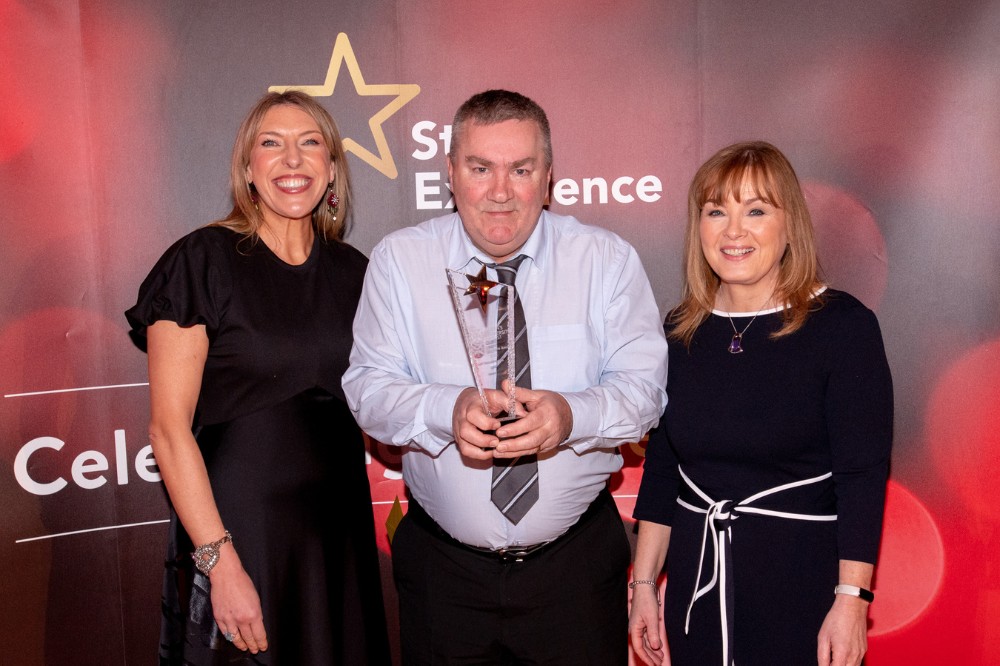 Kevin Campbell - Innovation Award winner (centre), with compere Alexandra Ford and Mairead Regan, Chair of the Staff Excellence Awards Judging Panel