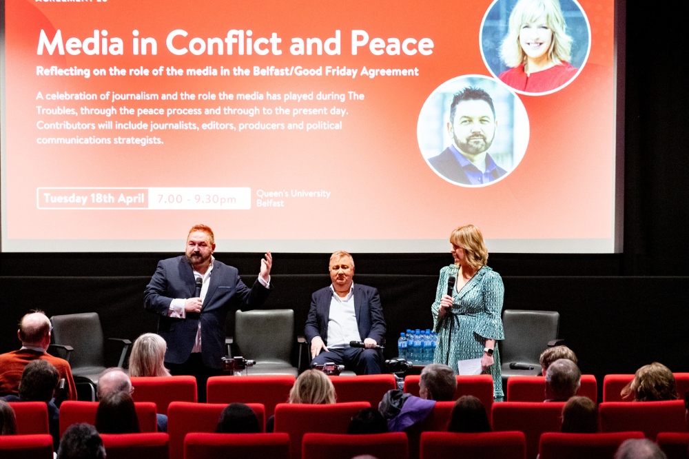 William Crawley welcoming guests to Media in Conflict and Peace at Agreement 25, onstage in the QFT with Stephen Grimason and Tara Mills