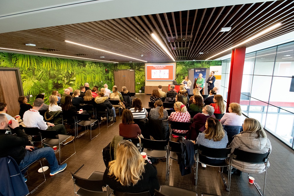 attendees seated in The Cube, One Elmwood, for the launch of Queen's Inclusive Employment Scheme 2023