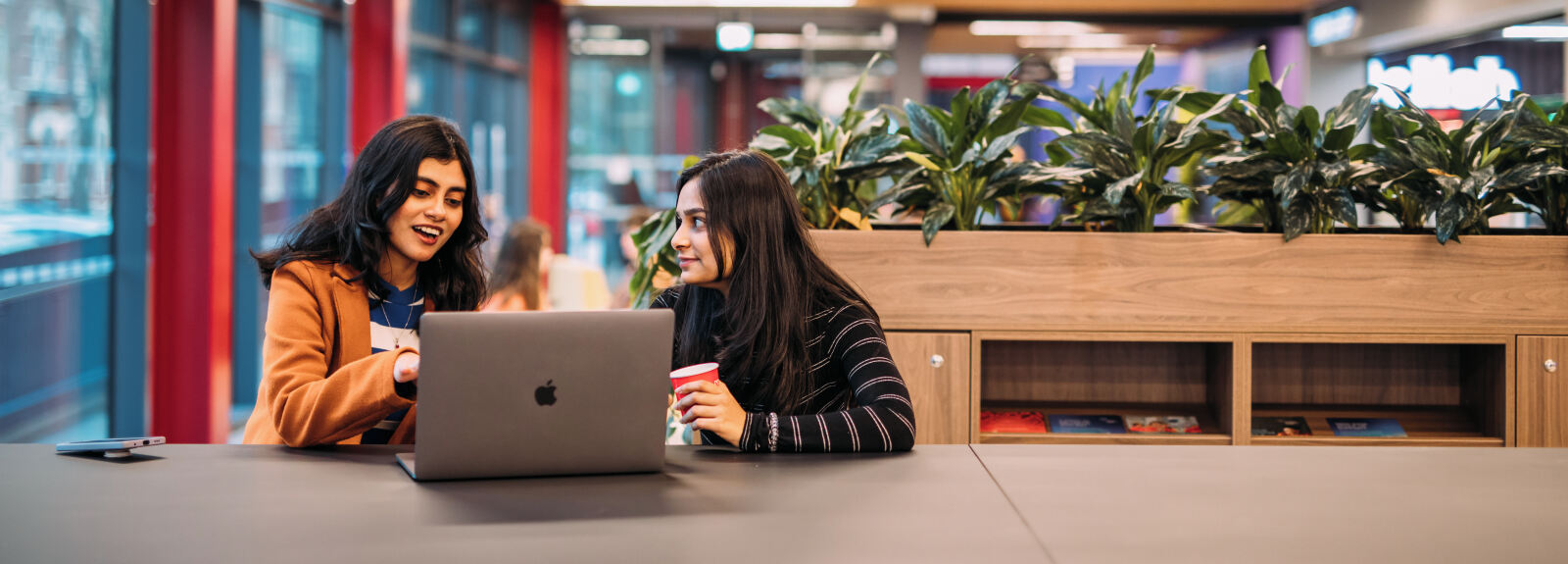 Two students working on a laptop