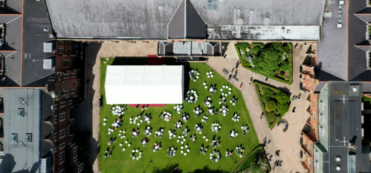 aerial view of Queen's quadrangle, showing summer graduation marquee and guests
