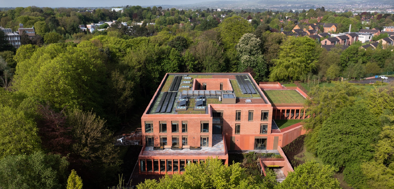 aerial view of new building on Riddel Hall site with trees and hills in the background