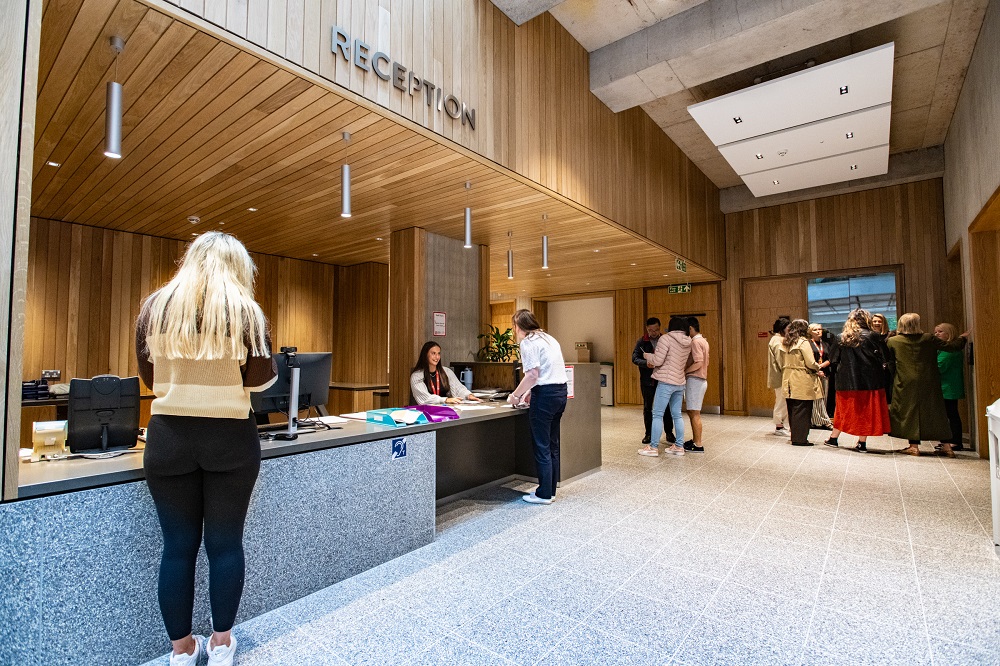 staff and students in the reception area of Queen's Business School