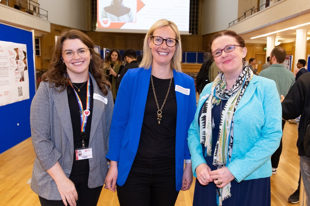three smiling postdocs/staff members at the poster presentation at Queen's Postdoc Showcase 2023