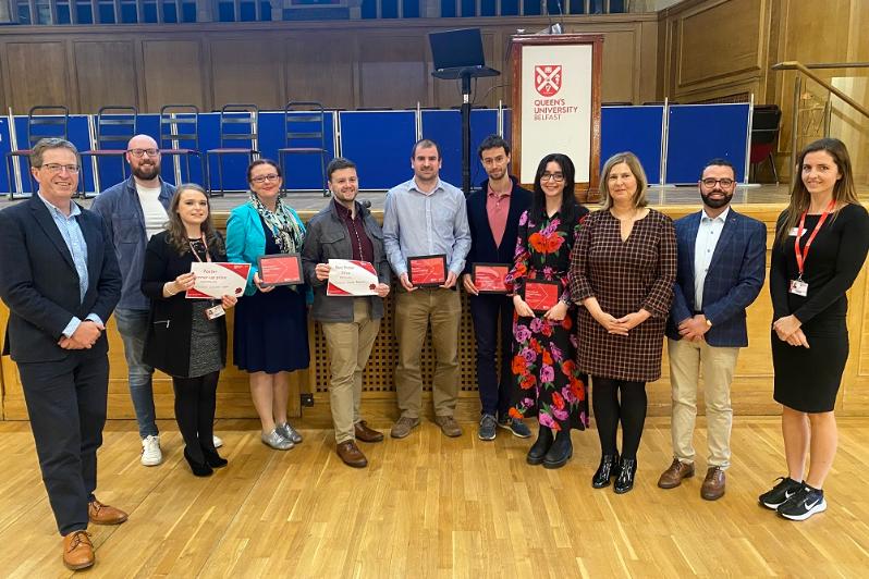 Postdoc Showcase 2023 - awards and prizewinners gathered at front of stage in the Whitla Hall