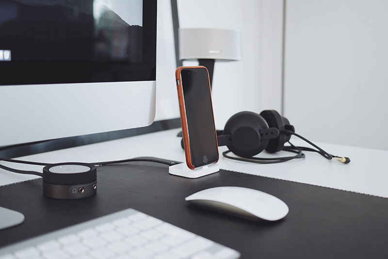 A desk with a computer monitor and headphones