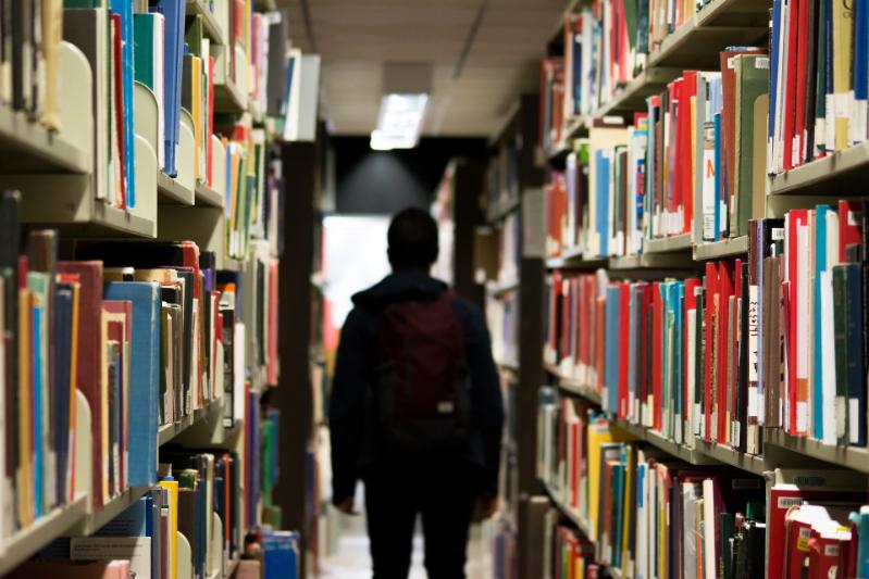 Image of person standing in between shelves