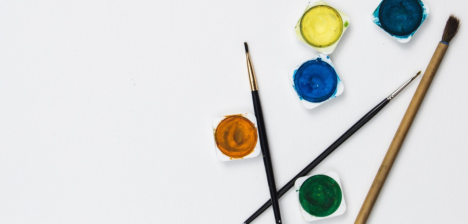 A white canvas with two paintbrushes and 5 paintpots