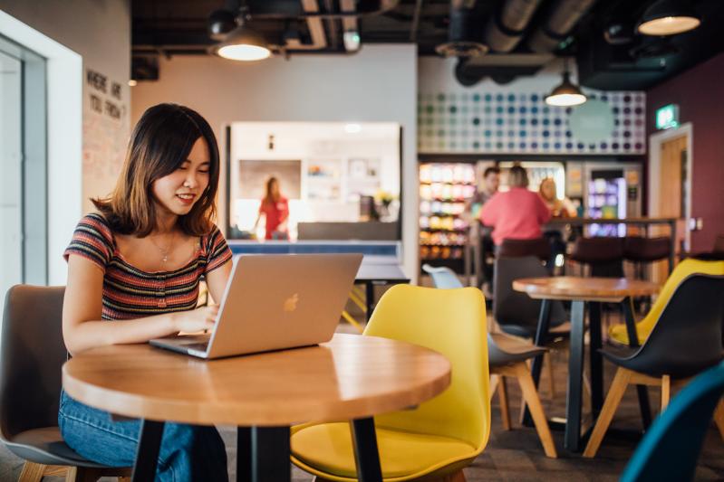 Student on laptop in a cafe