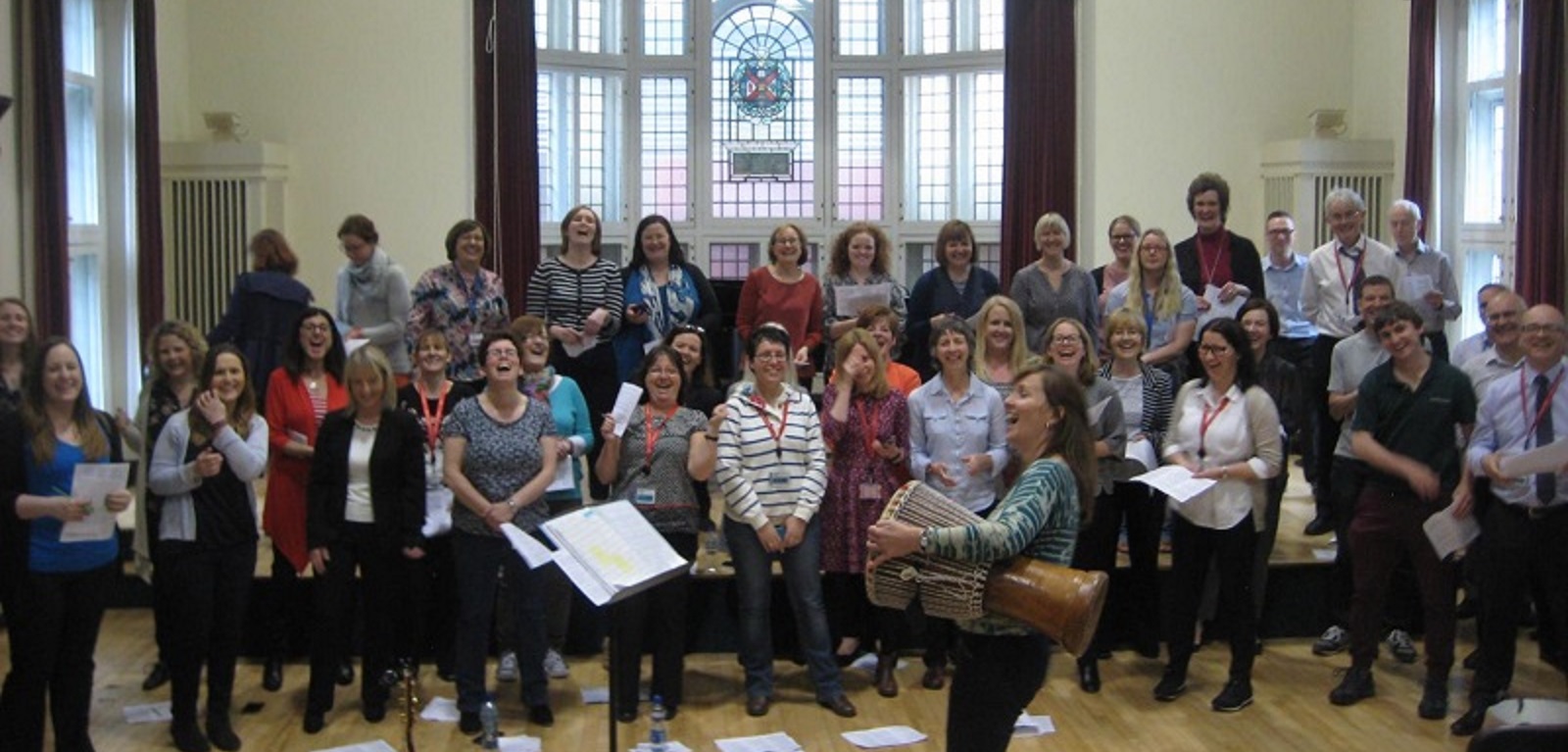 Queen's University Staff Wellbeing Choir practising and laughing in the Harty Room at Queen's