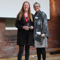 Ashleen Crowe accepts trophy from Baroness Ritchie