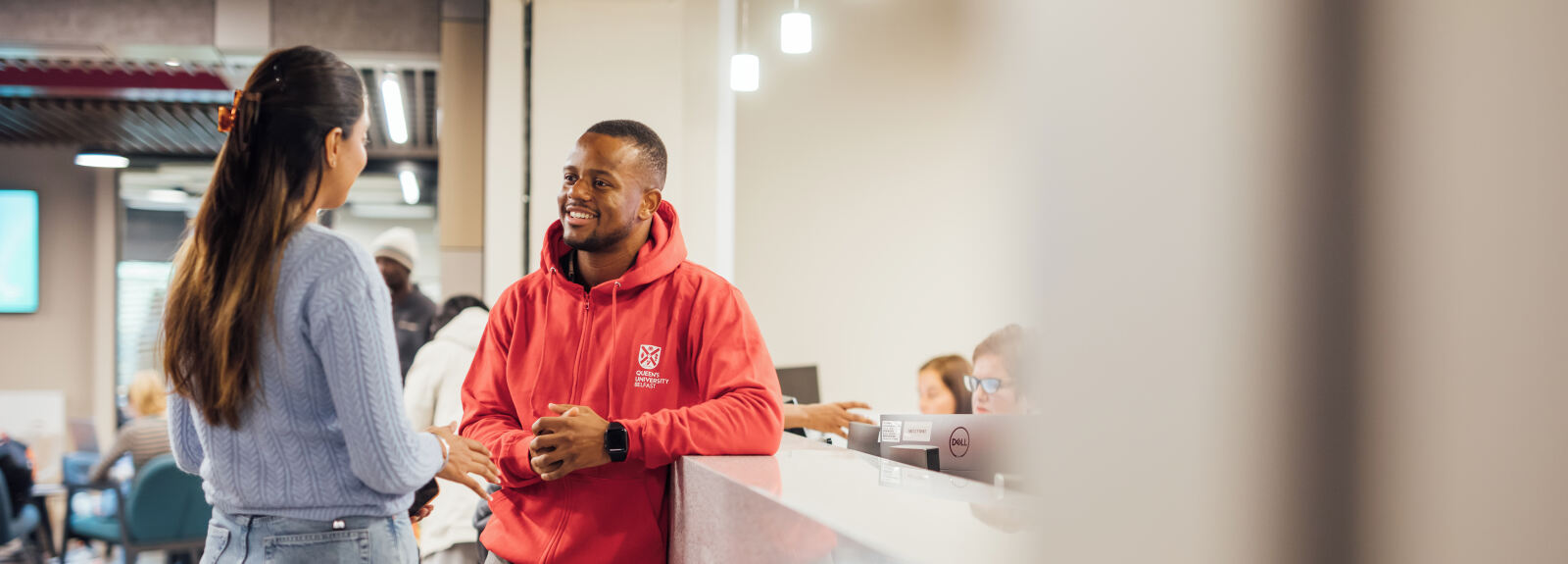 student getting advice from red hoodie volunteer