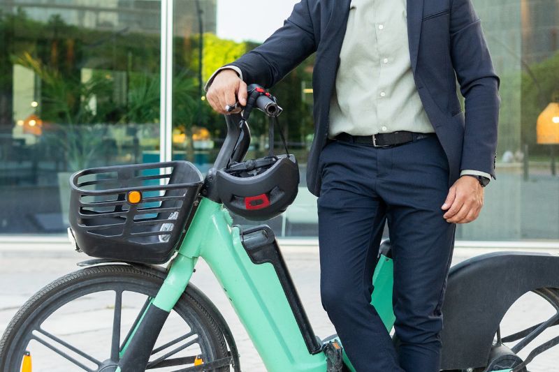 man in suit standing in front of an e-bike