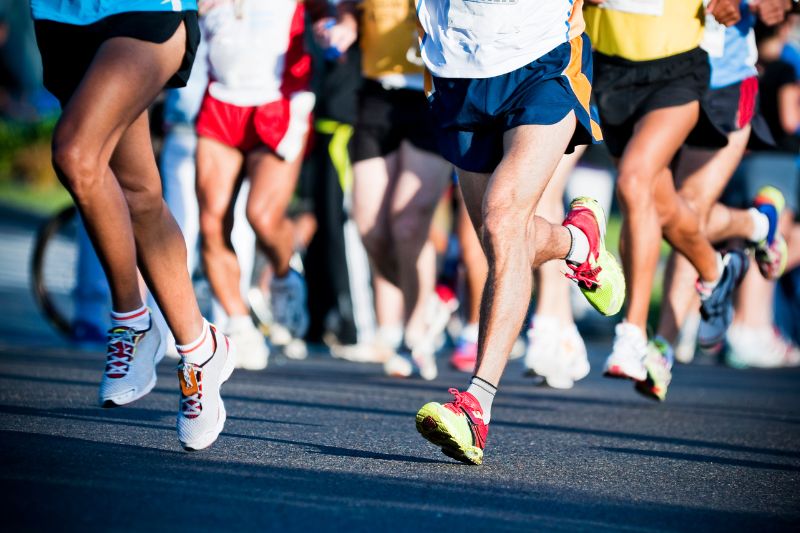 runners in a marathon or road race, pictured from the waist down