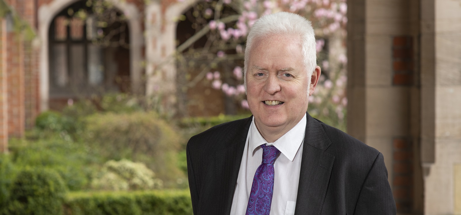 Professor Mark Lawler standing under the clock tower in Queen's quadrangle, March 2019