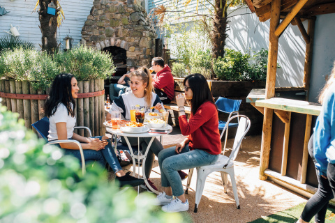 Three students eating outside the Parlour bar