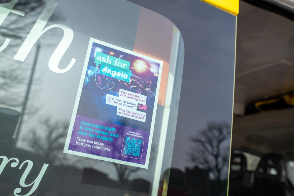 Ask for Angela poster stuck to the inside of a vehicle window