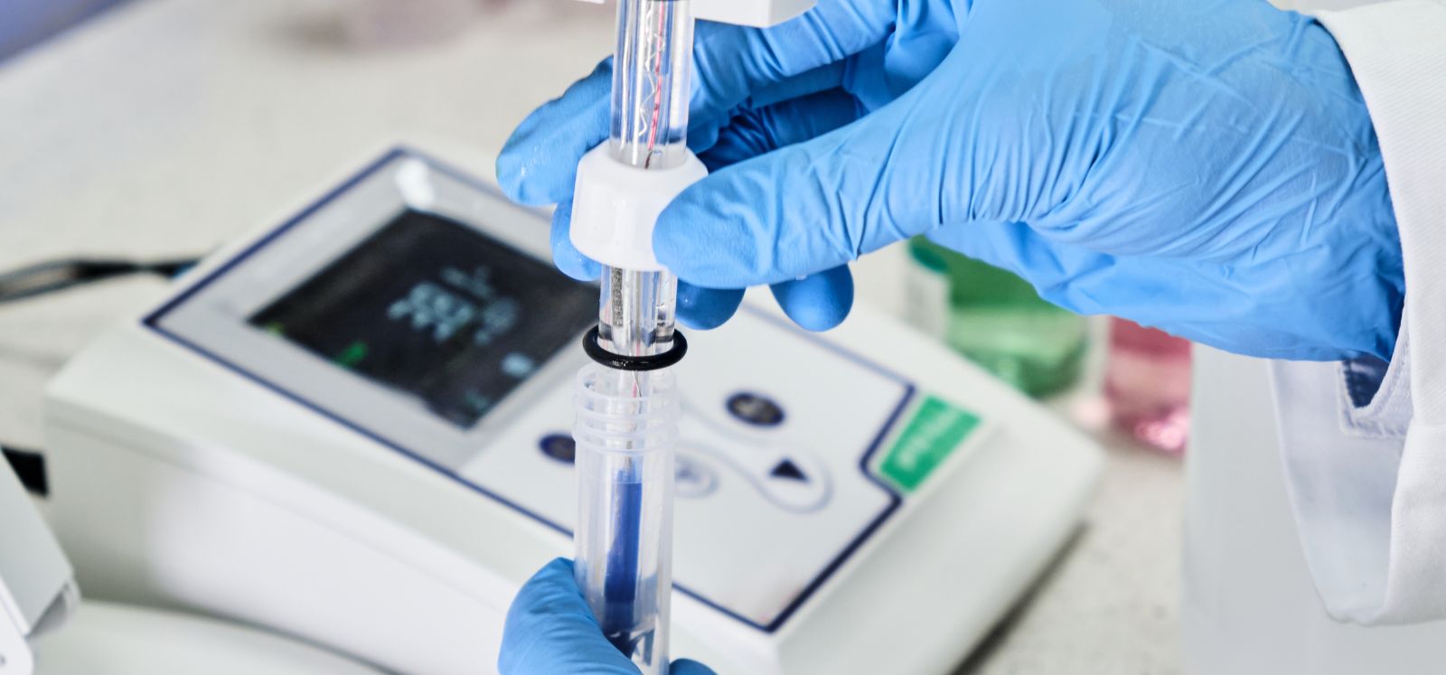 person checking the pH level of a liquid sample in a lab